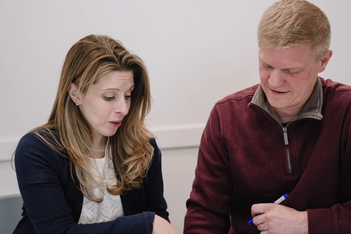 Colleagues in a serious business discussion over laptop and notes.