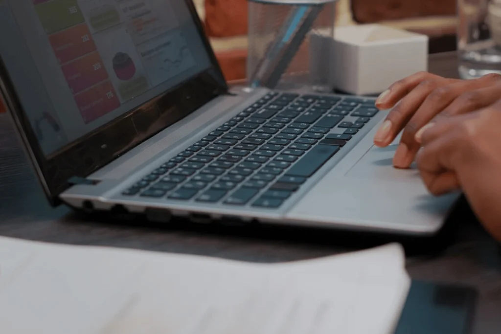 A person typing on a laptop computer, focused and engaged in their work.
