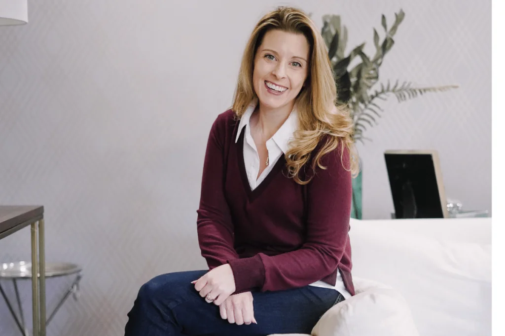 Nora Sudduth posing with a friendly smile in a smart casual outfit.