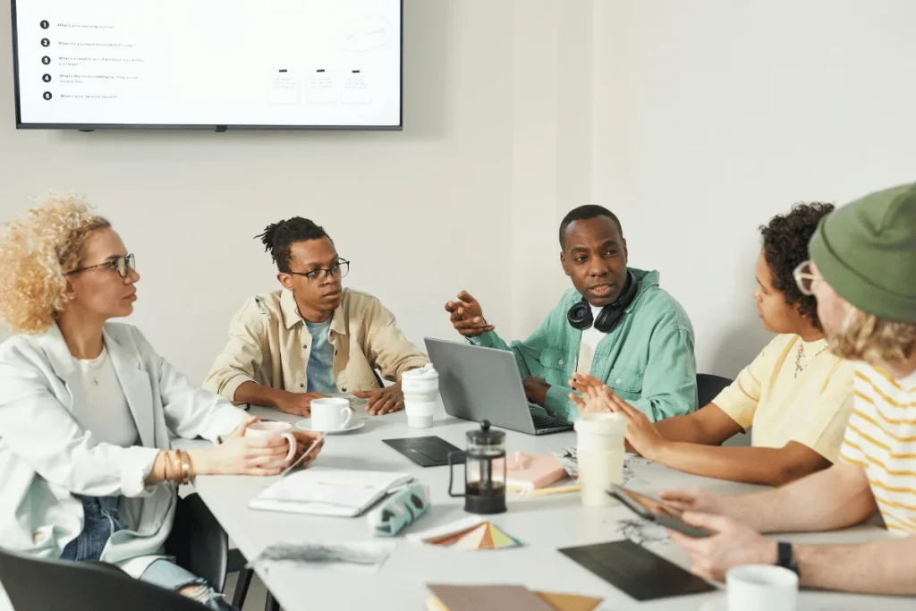 Diverse team collaborating during business meeting with laptop.