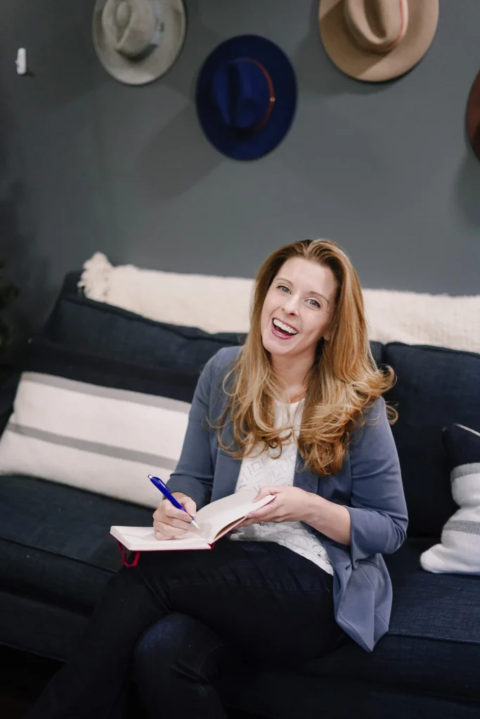 Smiling sales consultant writing in notebook during client session.