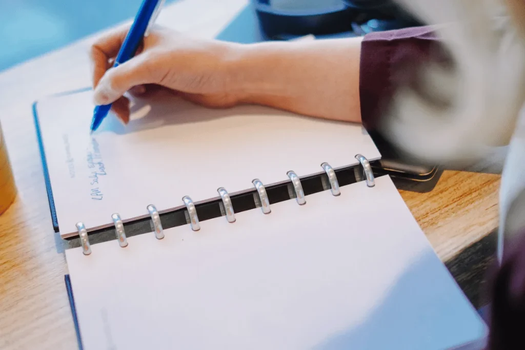 Close-up of Nora Sudduth’s hand penning down thoughts.