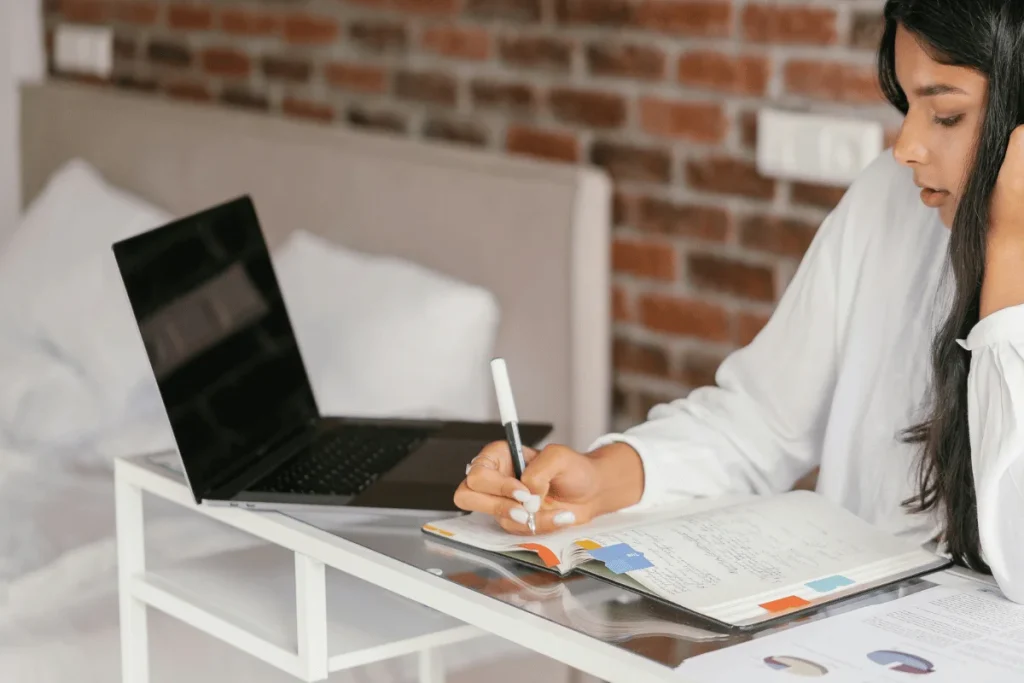 Virtual assistant managing online communication on laptop at desk.
