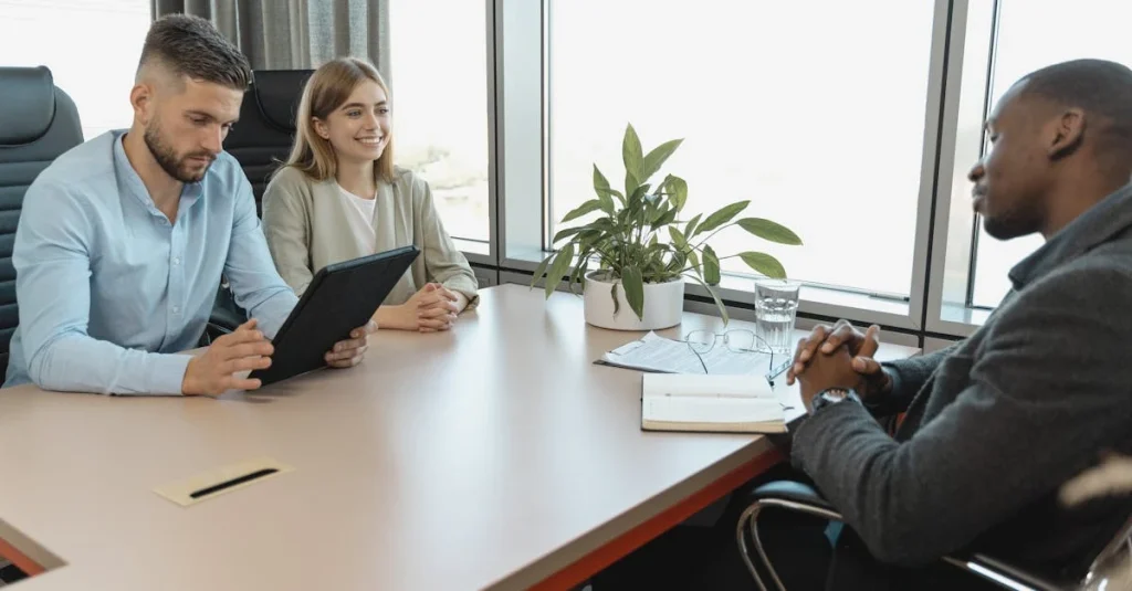Three professionals meet in a modern office, showcasing business collaboration and productive workplace communication.