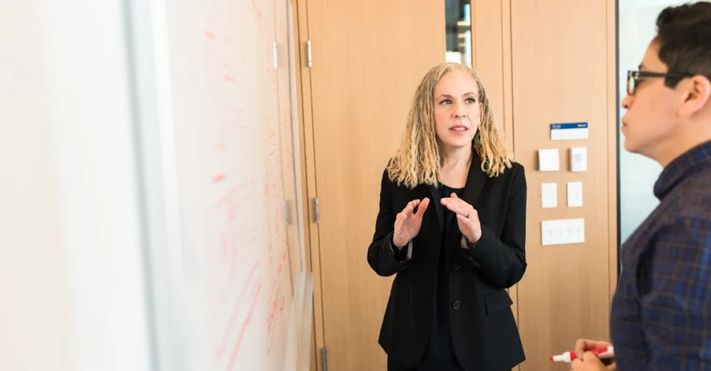 Marketing consultant in black blazer explaining strategy to client during office meeting discussion.