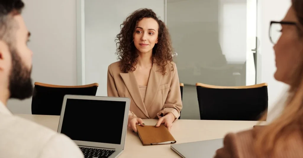 Woman in a suit leads a conference room discussion, emphasizing professional business collaboration and team communication.