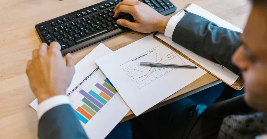 Businessman analyzing colorful bar charts and data reports on desk, identifying customer acquisition roadblocks.